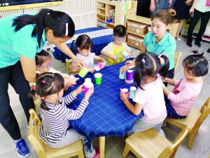 　天河实验幼儿园阳光园区教师在指导孩子们做手工。